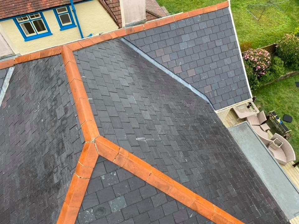 Slate roof after cleaning, with orange ridge tiles